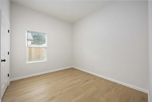 an empty room with wooden floor and closet