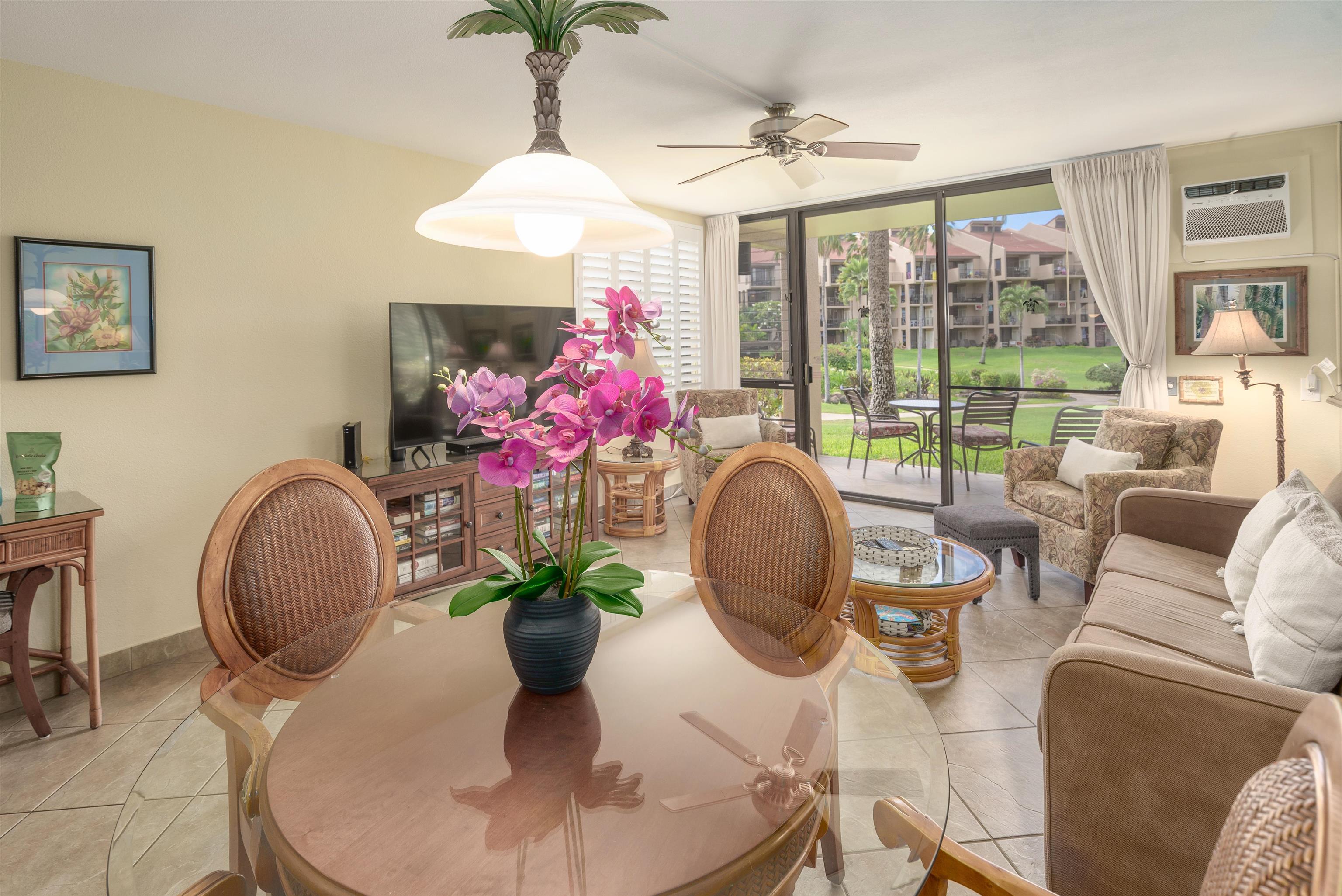 2695 South Kihei Road, Unit 2102 Kihei, HI 96753 - Photo 13 of 35 a dining room with furniture a potted plant and a chandelier