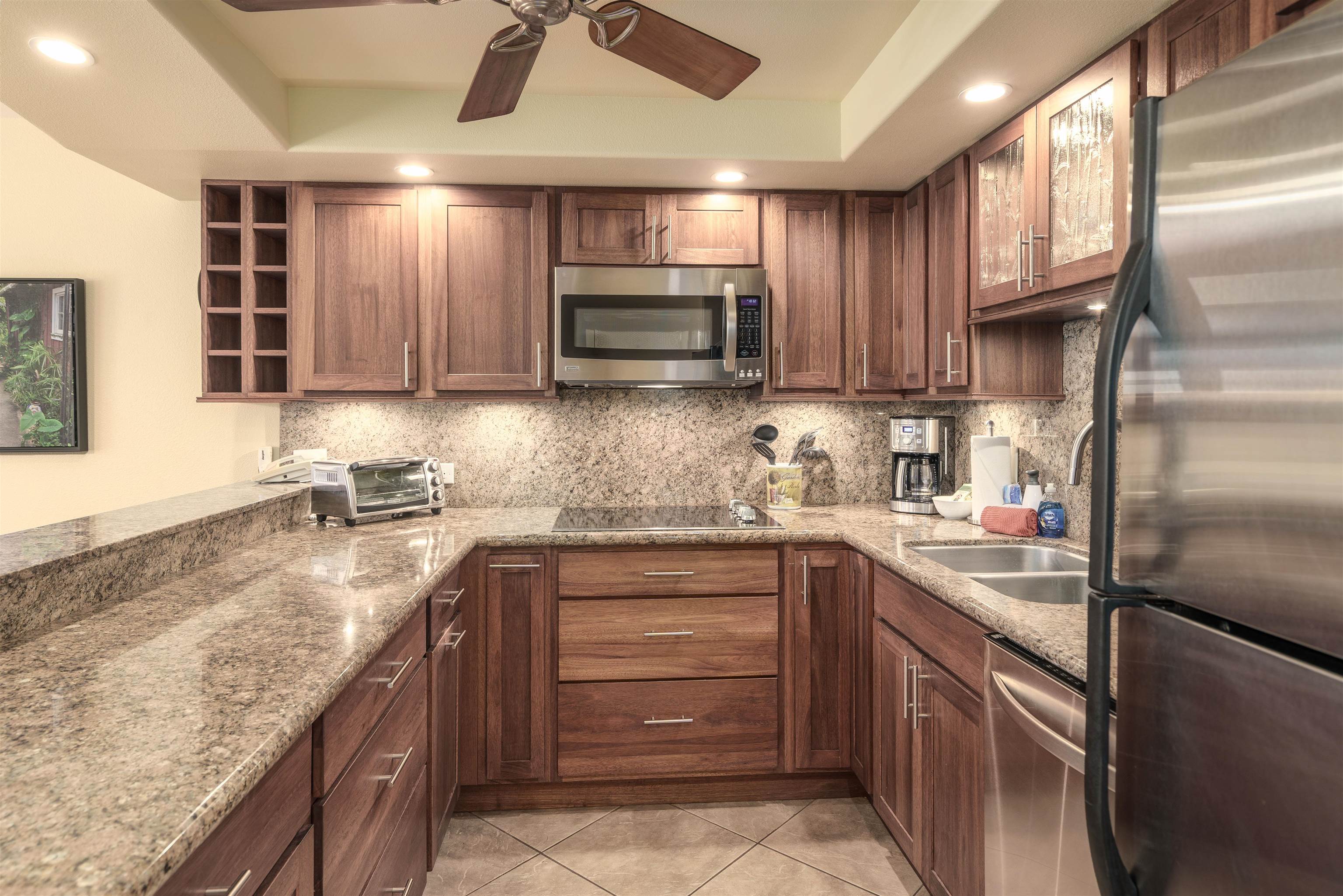 2695 South Kihei Road, Unit 2102 Kihei, HI 96753 - Photo 2 of 35 a kitchen with stainless steel appliances granite countertop a sink a stove a refrigerator cabinets and a sink