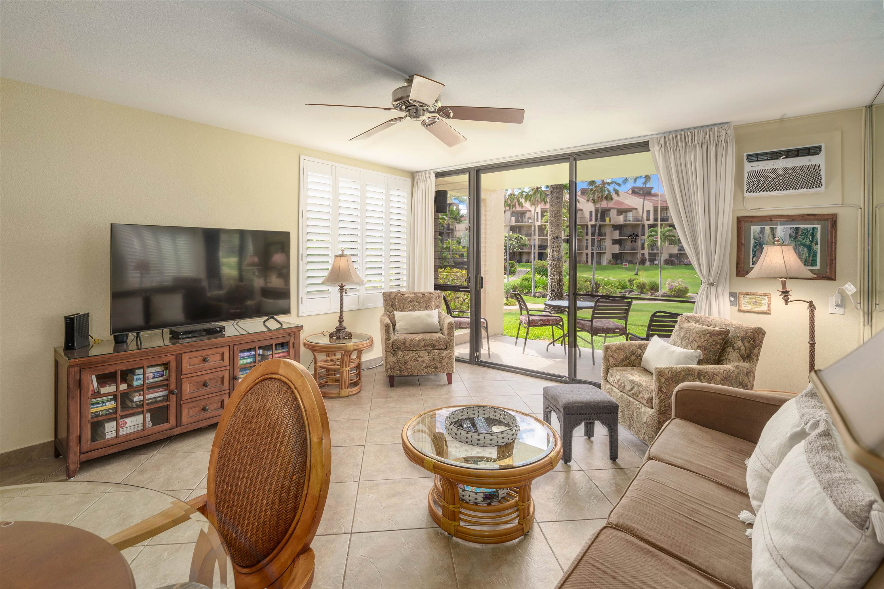 2695 South Kihei Road, Unit 2102 Kihei, HI 96753 - Photo 3 of 35 a living room with furniture a flat screen tv and a large window