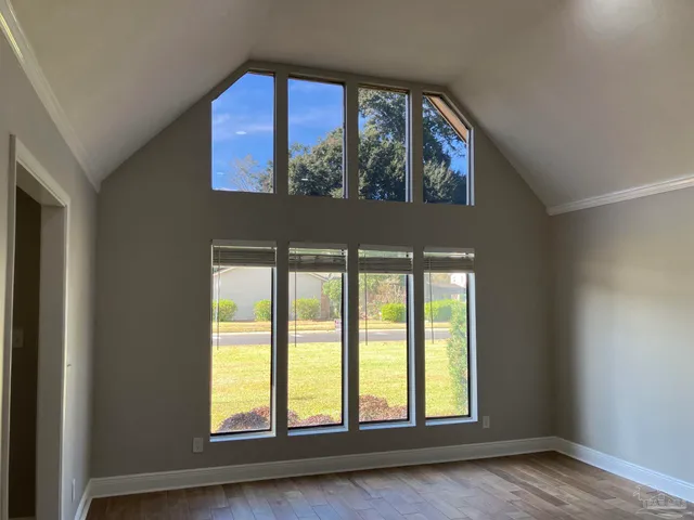 a view of a room with wooden floor table and chairs