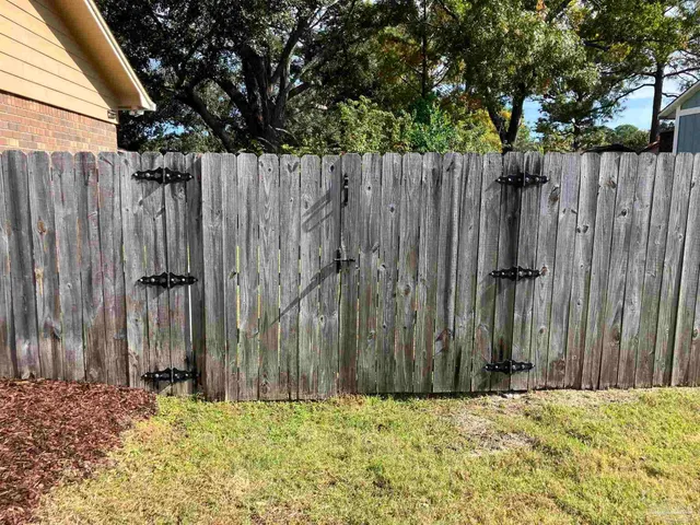 a view of a wooden fence with a trees in the background
