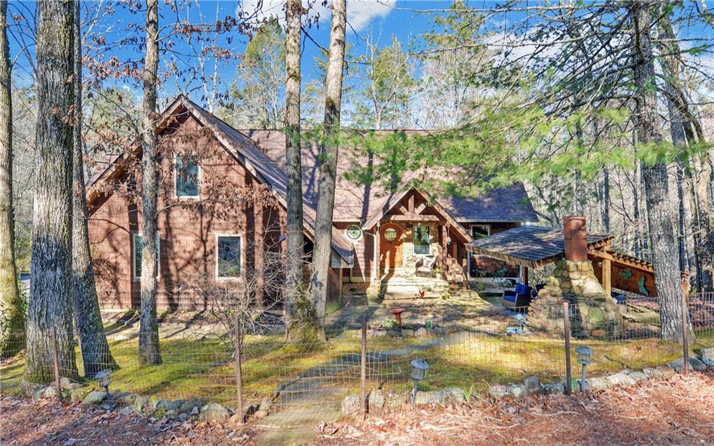 a view of a house with pool and trees in the background