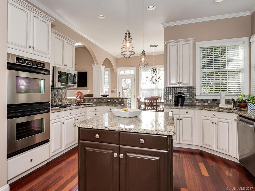 1940 Clark Elliot Street Fort Mill, SC 29708 - Photo 7 of 22 a kitchen with granite countertop a stove a sink and a microwave