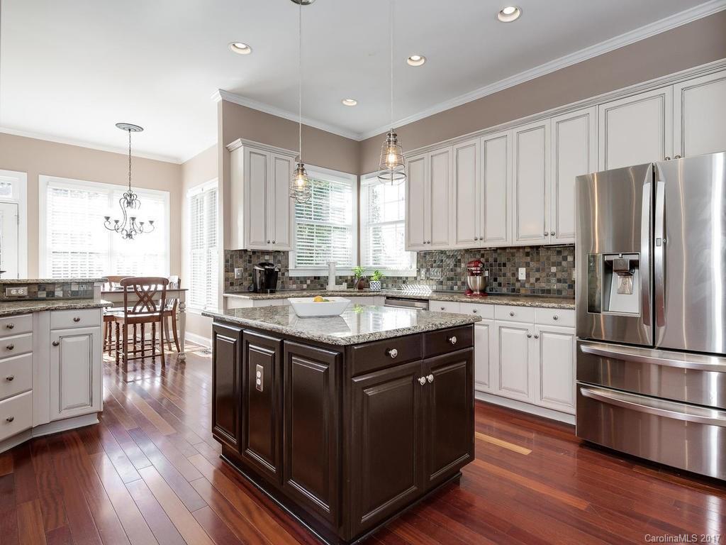 1940 Clark Elliot Street Fort Mill, SC 29708 - Photo 8 of 22 a kitchen with stainless steel appliances granite countertop a stove a sink dishwasher a refrigerator and white cabinets with wooden floor