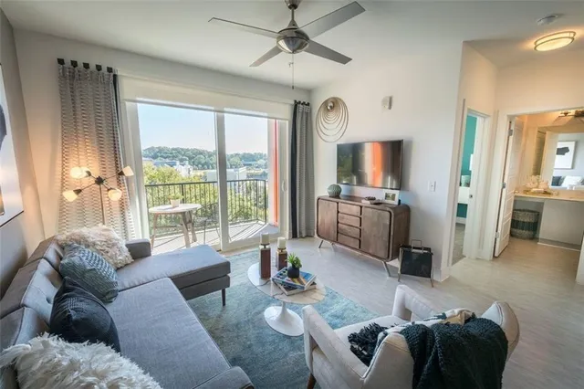 a room with stainless steel appliances kitchen island granite countertop a table chairs in it and a wooden floor