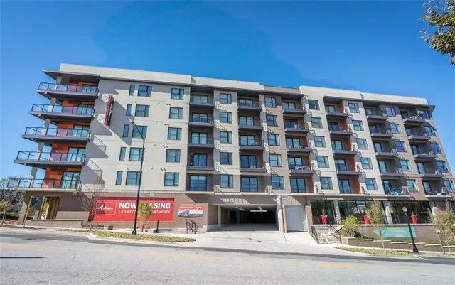 a living room with furniture kitchen view and a wooden floor