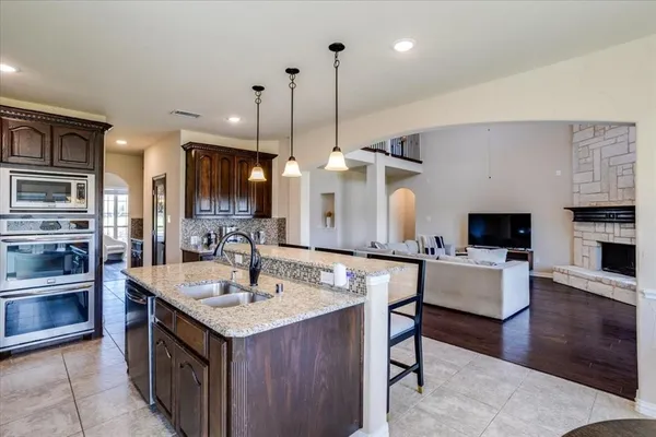 a kitchen with granite countertop a sink cabinets and stainless steel appliances