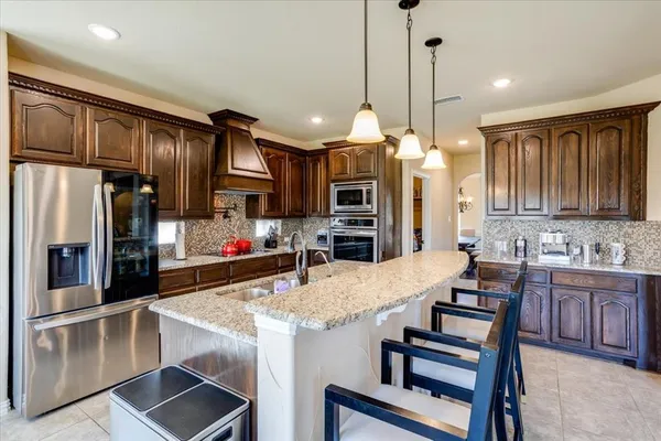 a kitchen with granite countertop a center island stainless steel appliances and cabinets