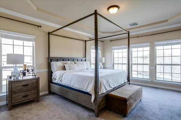 a bed sitting in a bedroom next to a window