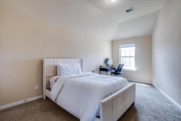 a large bed sitting in a bedroom next to a window