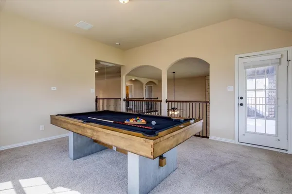 a living room with furniture pool table and a window