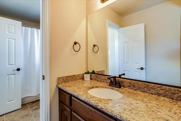 a bathroom with a granite countertop sink and a mirror