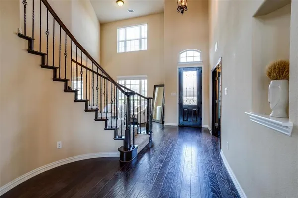 a view of a hallway with wooden floor and staircase