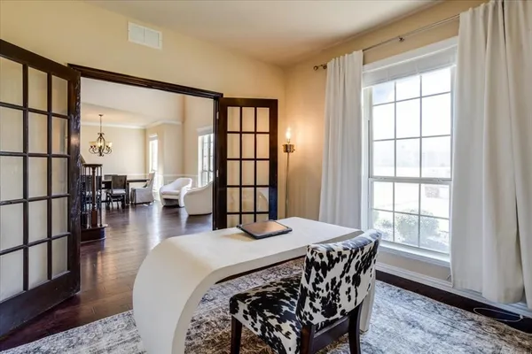 a bedroom with a bed a table and windows
