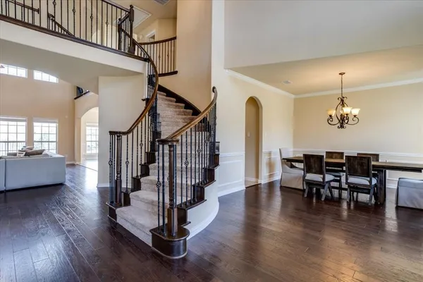 a view of a dining room with furniture a chandelier and wooden floor