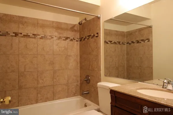 a bathroom with a granite countertop sink toilet and shower