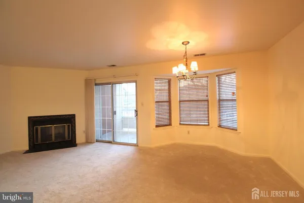 a view of an empty room with a fireplace and a window