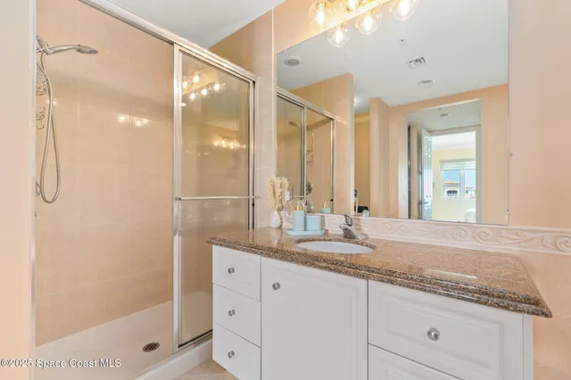 a bathroom with a granite countertop toilet sink and mirror