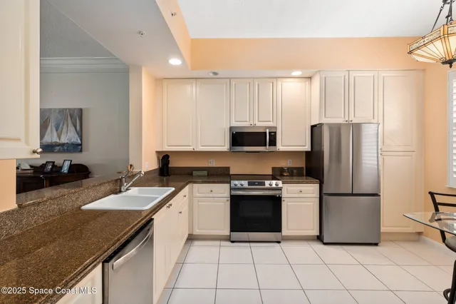 a kitchen with stainless steel appliances granite countertop a refrigerator sink and stove