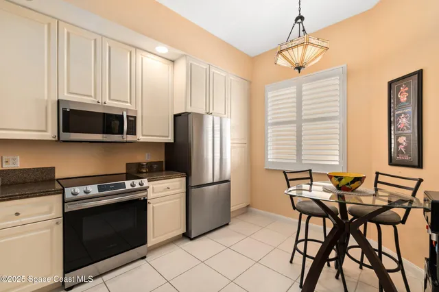 a kitchen with stainless steel appliances granite countertop a stove a refrigerator and a microwave