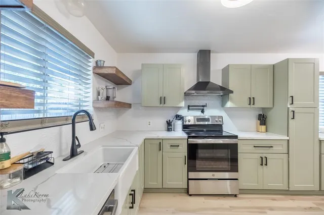 a kitchen with stainless steel appliances a stove a sink and a refrigerator