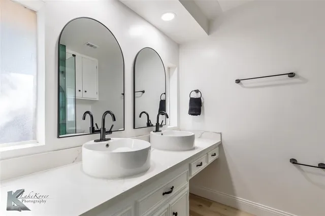 a bathroom with a double vanity sink and a mirror