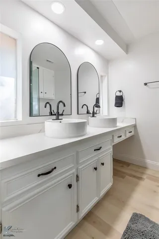 a bathroom with a double vanity sink and a mirror