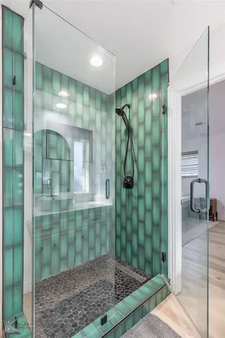 a bathroom with a glass shower door and a sink