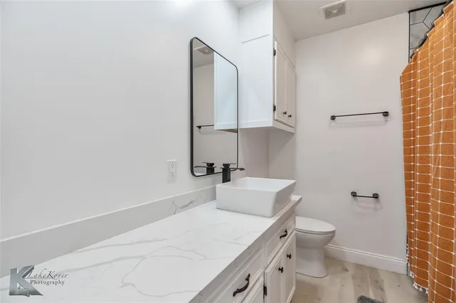 a bathroom with a sink a toilet and mirror