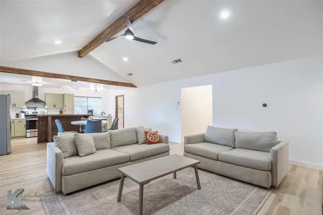 a living room with furniture and view of kitchen