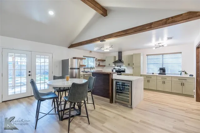 a kitchen with a table chairs and wooden floor