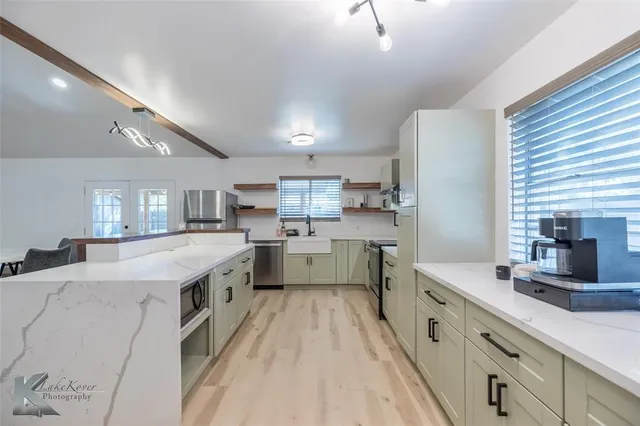 a large kitchen with stainless steel appliances lots of counter space and a sink