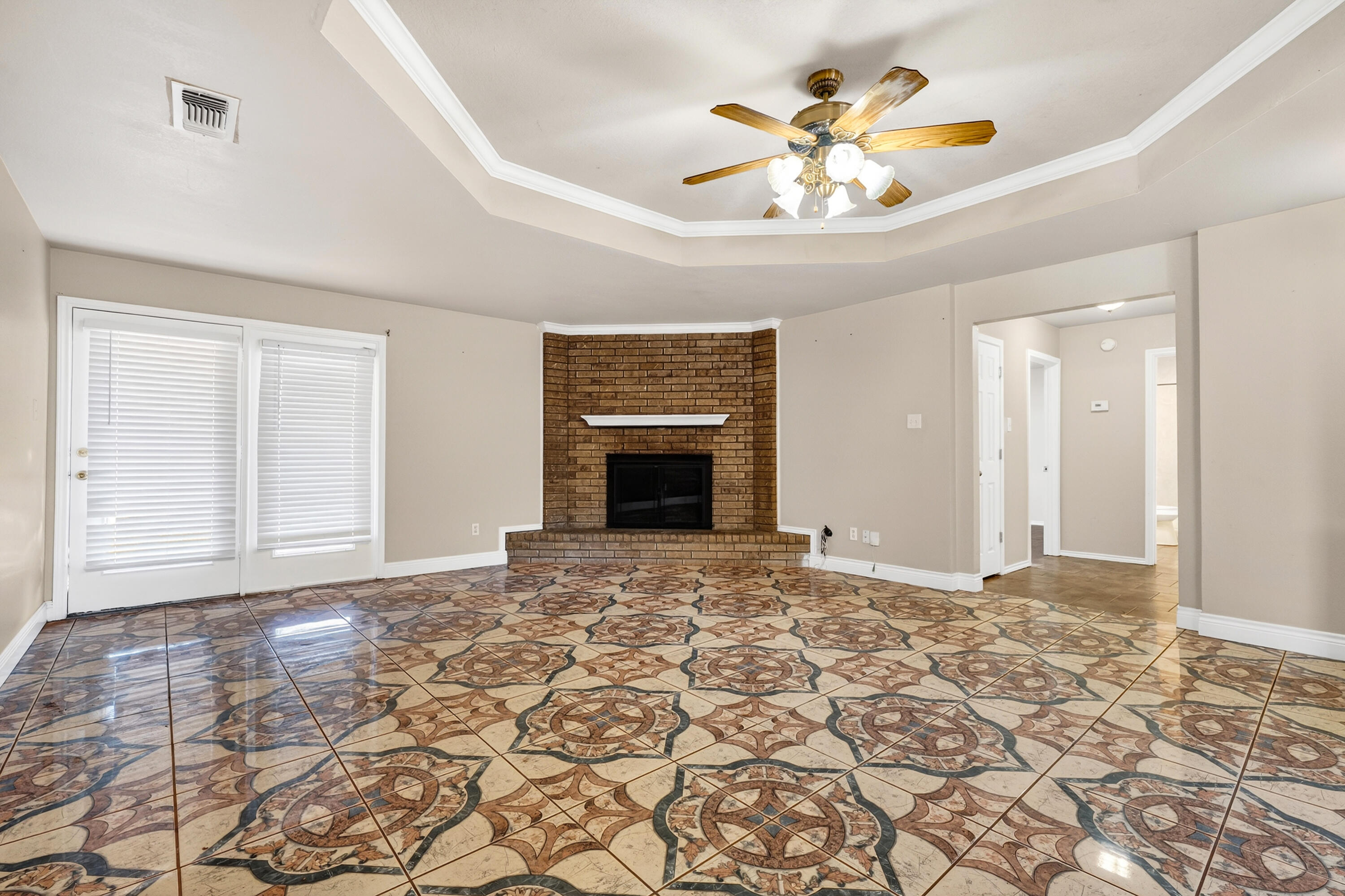 2415 93rd Street Lubbock, TX 79423 - Photo 7 of 24 a view of an empty room with chandelier fan and fire place