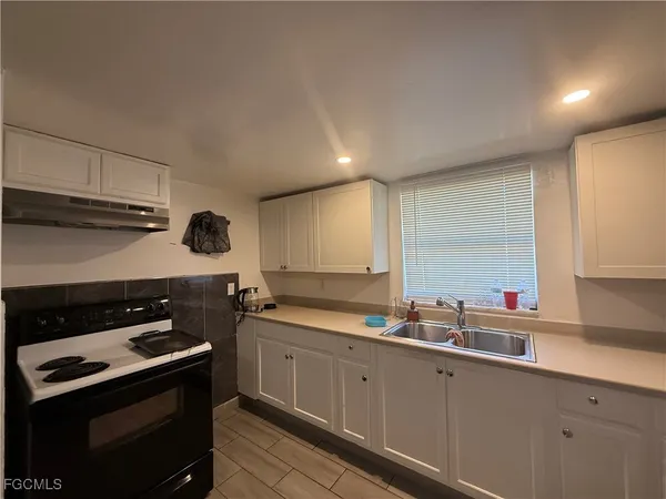 a kitchen with a sink stove top oven and cabinets