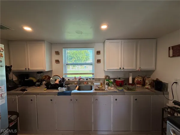 a kitchen with kitchen island granite countertop a sink and a stove