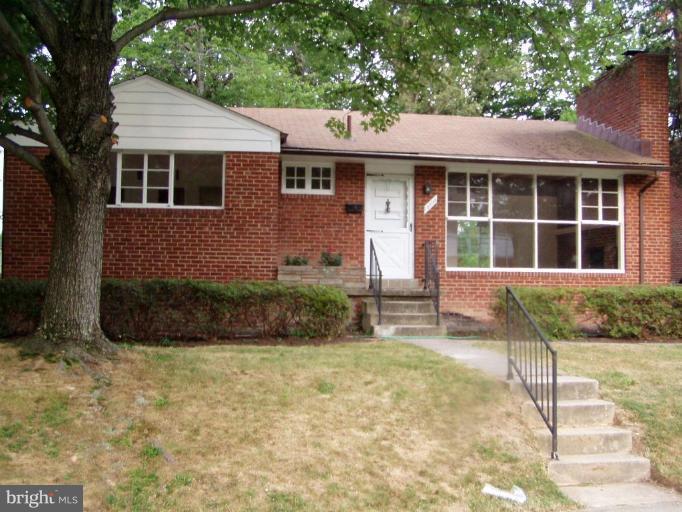 a front view of a house with a yard and potted plants