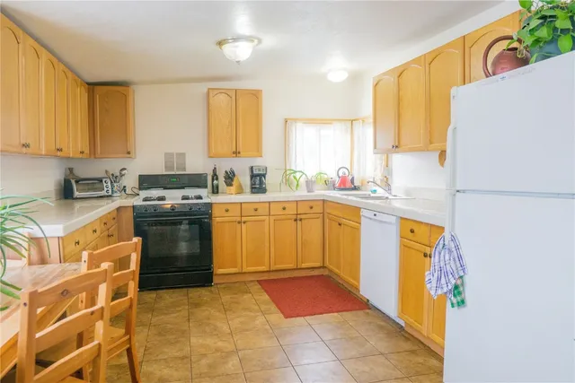 a kitchen with stainless steel appliances granite countertop a stove a sink dishwasher and a refrigerator