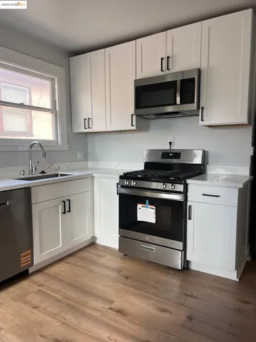 a kitchen with stainless steel appliances white cabinets and a stove top oven
