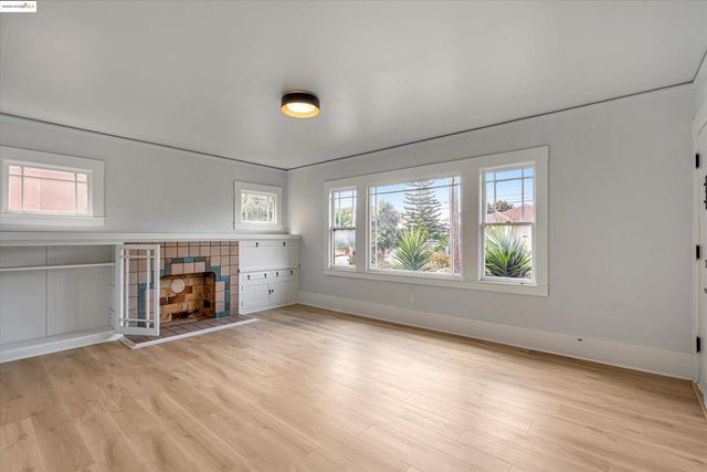 an empty room with windows and fireplace
