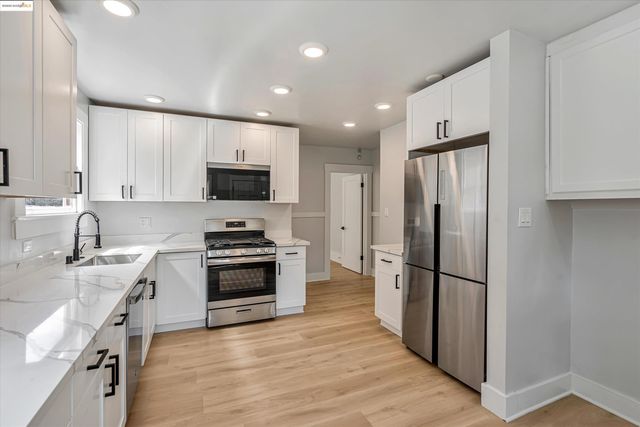 a kitchen with stainless steel appliances granite countertop a refrigerator stove and sink