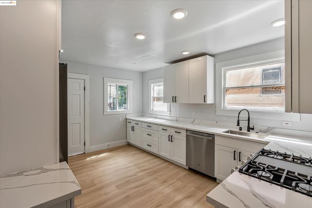 a large white kitchen with sink and stove