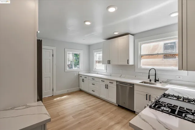 a large white kitchen with sink and stove