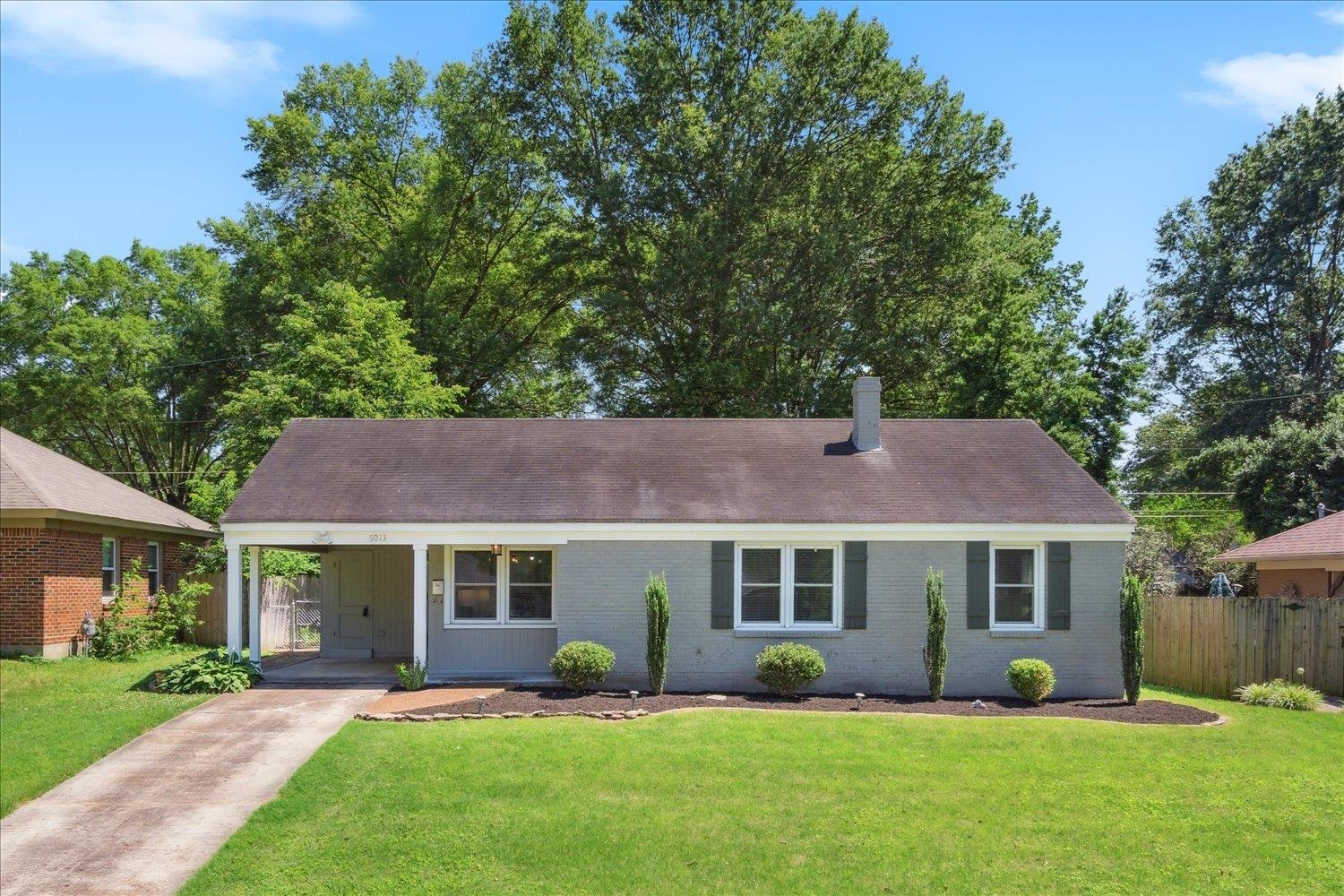 a front view of a house with a garden and yard