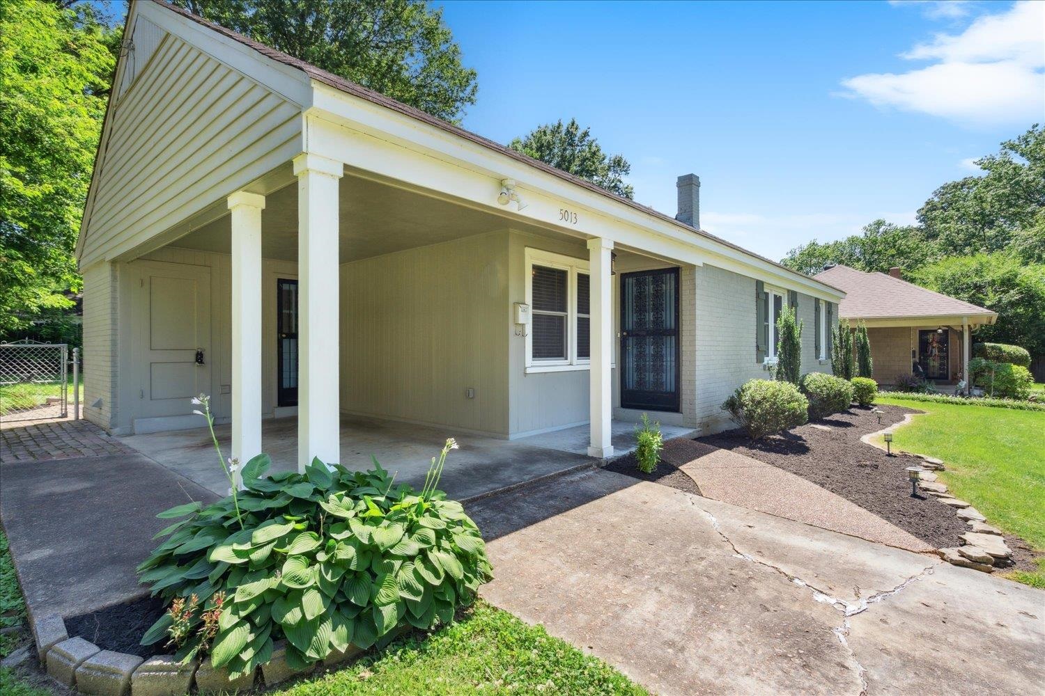 5013 New Castle Road Memphis, TN 38117 - Photo 3 of 28 a front view of a house with a yard and potted plants
