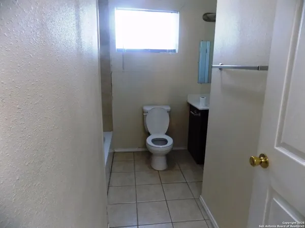 a white toilet sitting in a bathroom next to a window