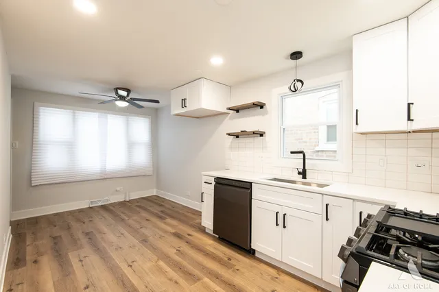 a kitchen with stainless steel appliances granite countertop a sink a stove a microwave and wooden cabinets