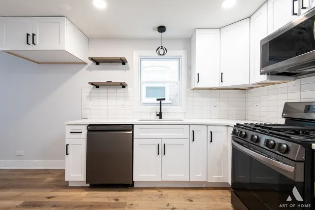 a kitchen with a sink a stove top oven and white stainless steel appliances