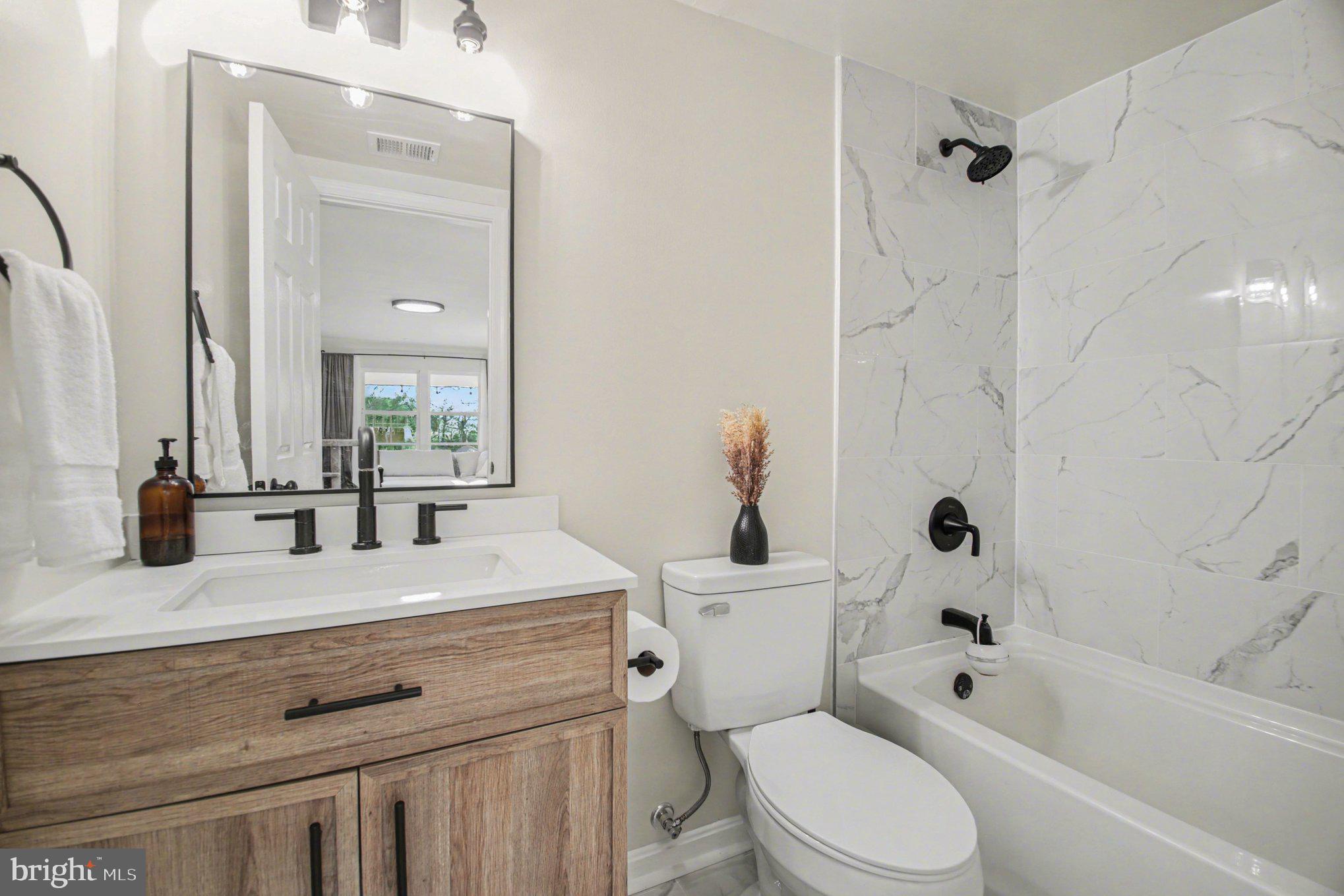 2137 Chapel Way King George, VA 22485 - Photo 34 of 65 a bathroom with a sink a toilet a mirror a vanity and bathtub