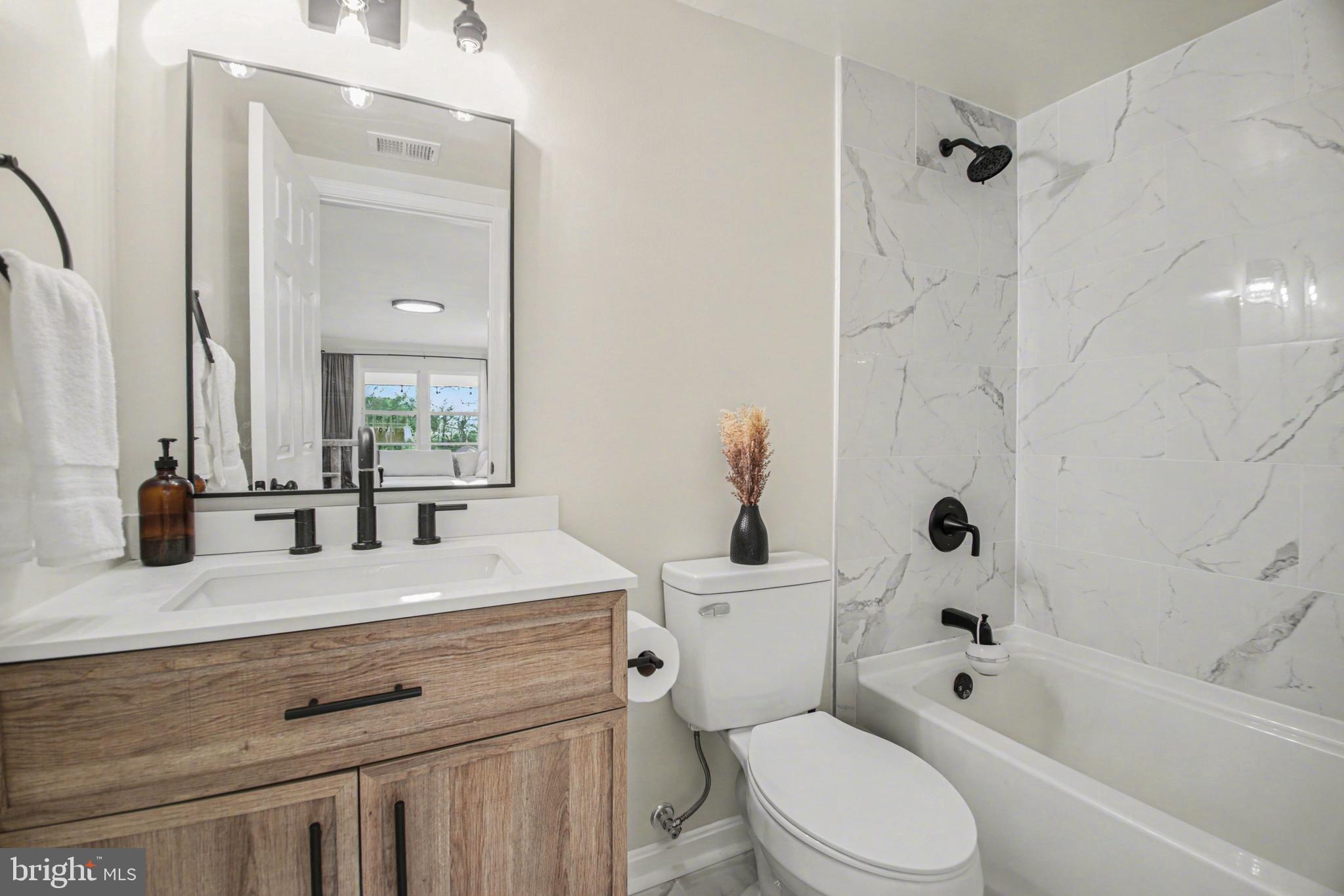 2137 Chapel Way King George, VA 22485 - Photo 38 of 65 a bathroom with a sink a toilet a mirror a vanity and bathtub